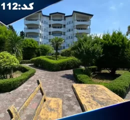 نمای سفید و محوطه سرسبز آپارتمان در عباس آباد